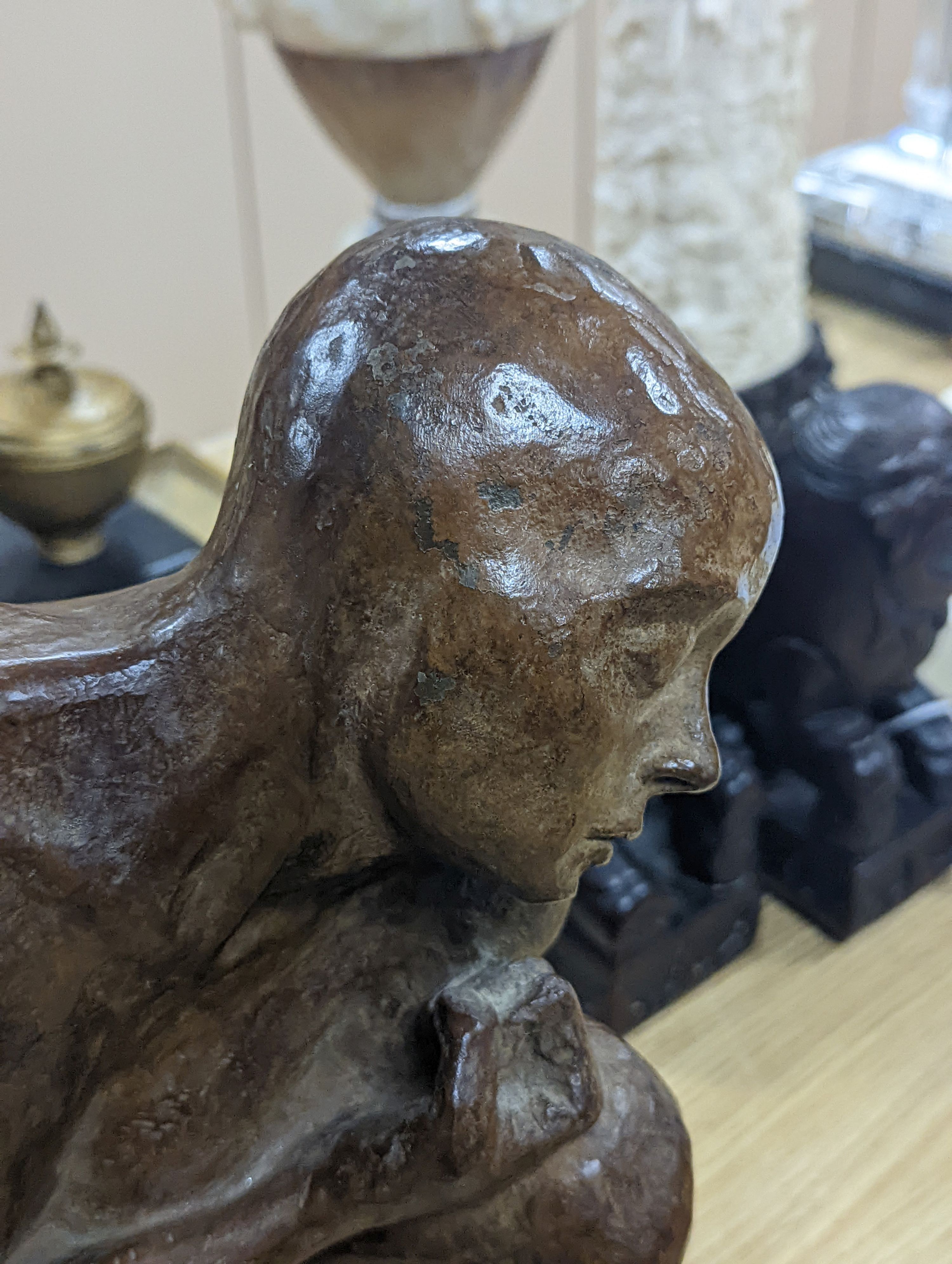 A contemporary bronze of a lady crouching with a thoughtful expression, unsigned - 31cm high